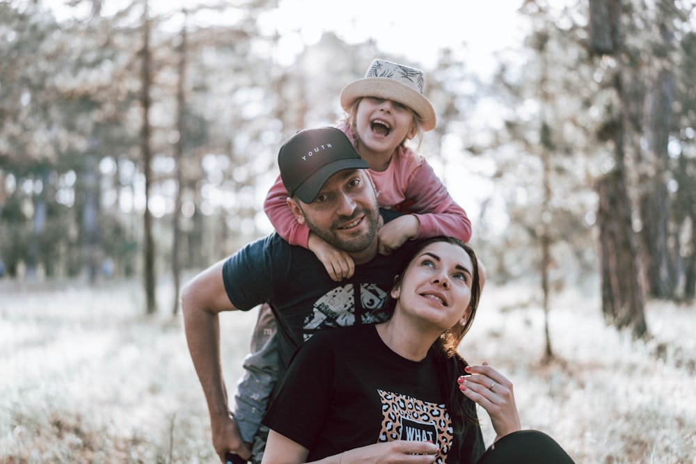 a man holding a little girl on his shoulders