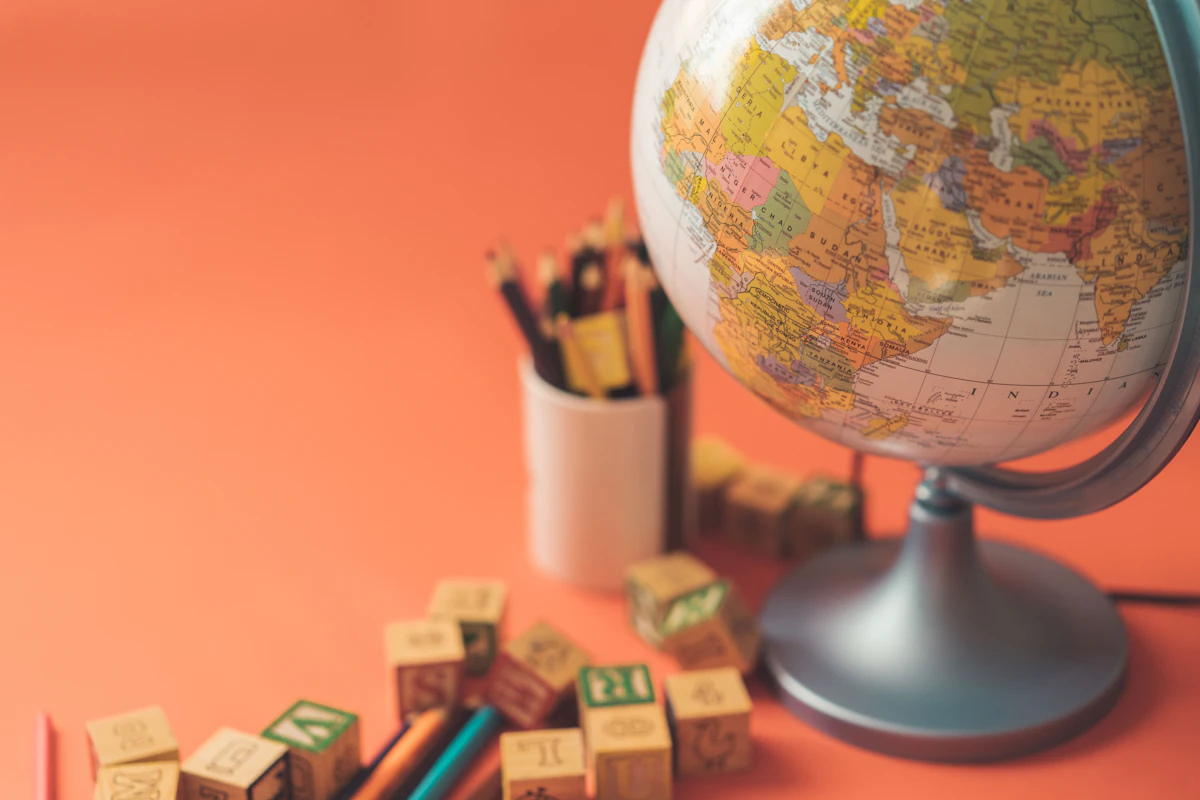 A globe surrounded by pencils and maps, Alexandr Podvalny / Unsplash