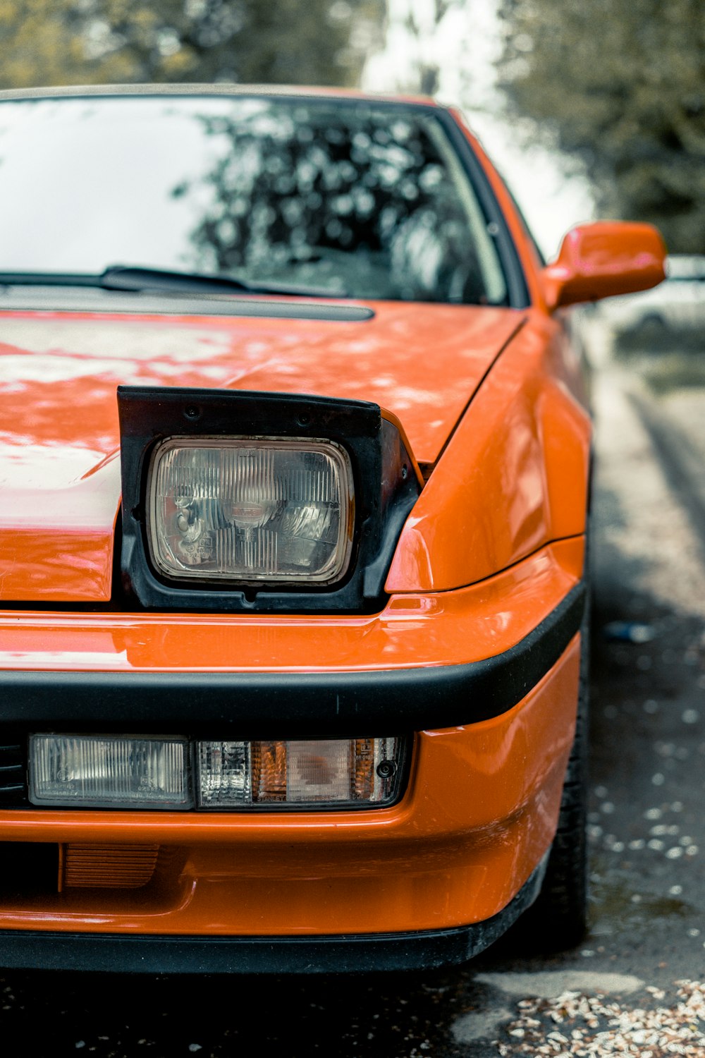 an orange car parked on the side of the road