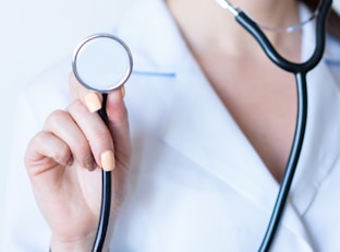 a woman in a white shirt holding a stethoscope