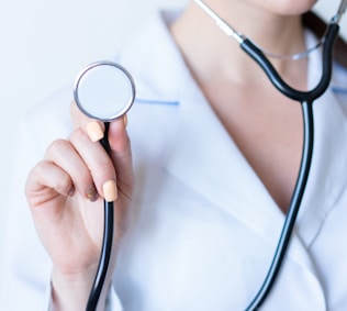 a woman in a white shirt holding a stethoscope