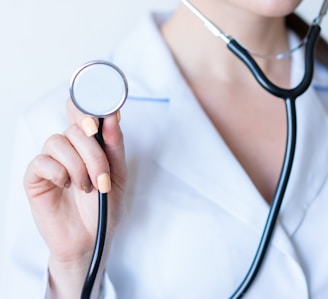 a woman in a white shirt holding a stethoscope