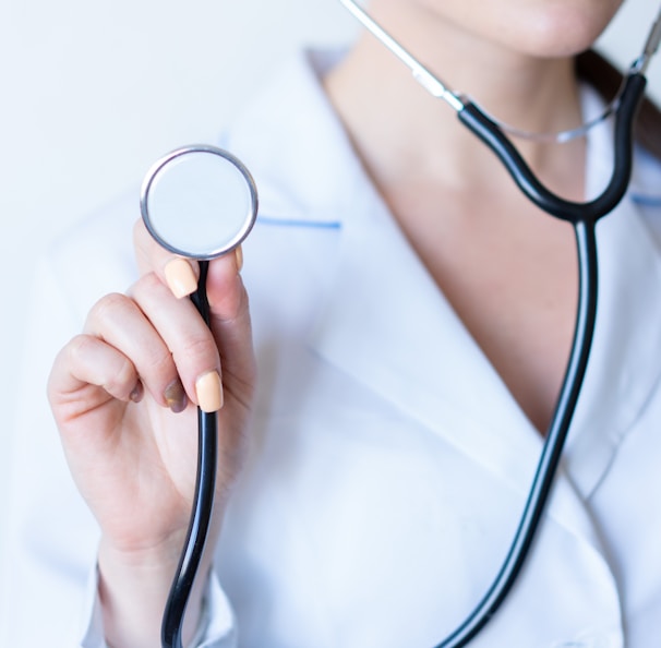 a woman in a white shirt holding a stethoscope