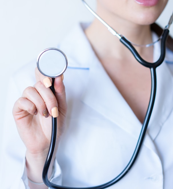 a woman in a white shirt holding a stethoscope