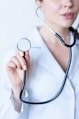a woman in a white shirt holding a stethoscope