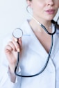 a woman in a white shirt holding a stethoscope