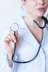 a woman in a white shirt holding a stethoscope