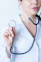 a woman in a white shirt holding a stethoscope