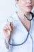 a woman in a white shirt holding a stethoscope