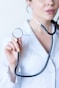a woman in a white shirt holding a stethoscope