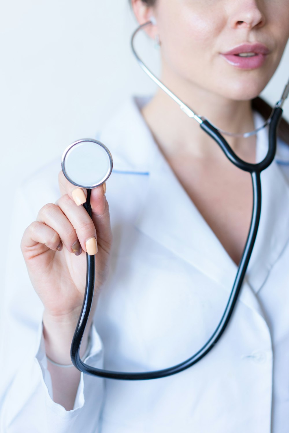 Une femme en chemise blanche tenant un stéthoscope