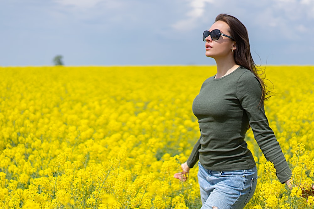 a woman standing in a field of yellow flowers