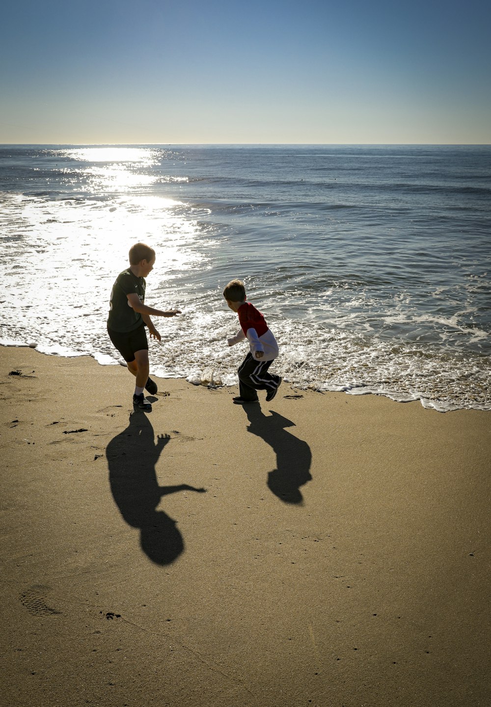 a man and a child playing on the beach