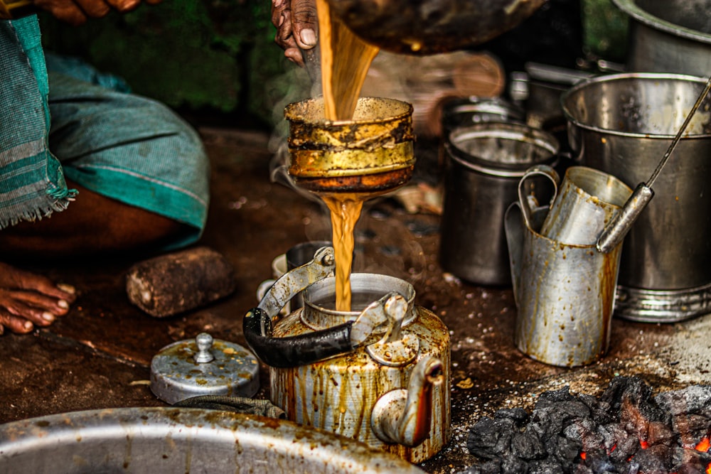 a person pouring something into a metal bowl