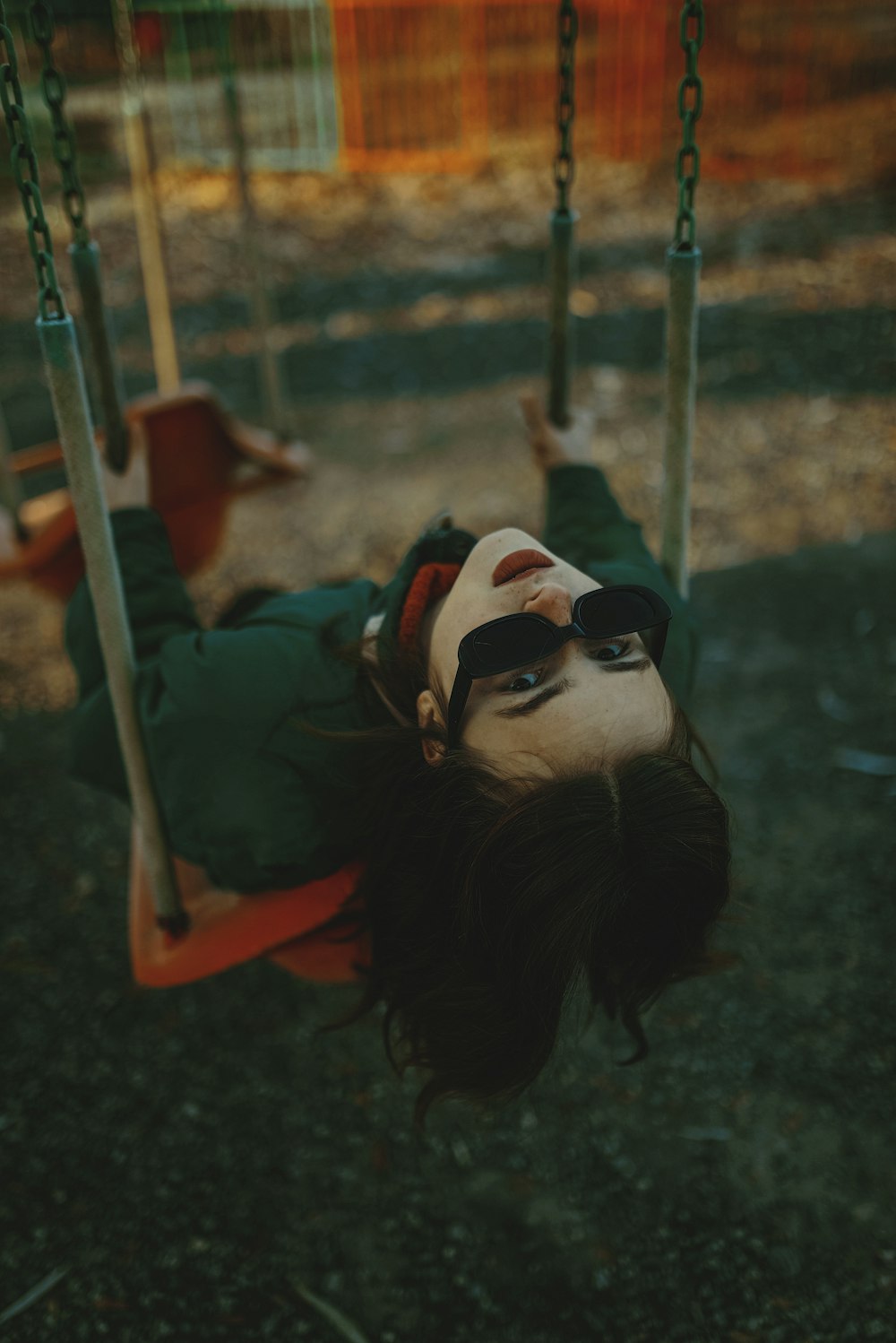 a person laying on a swing in a park