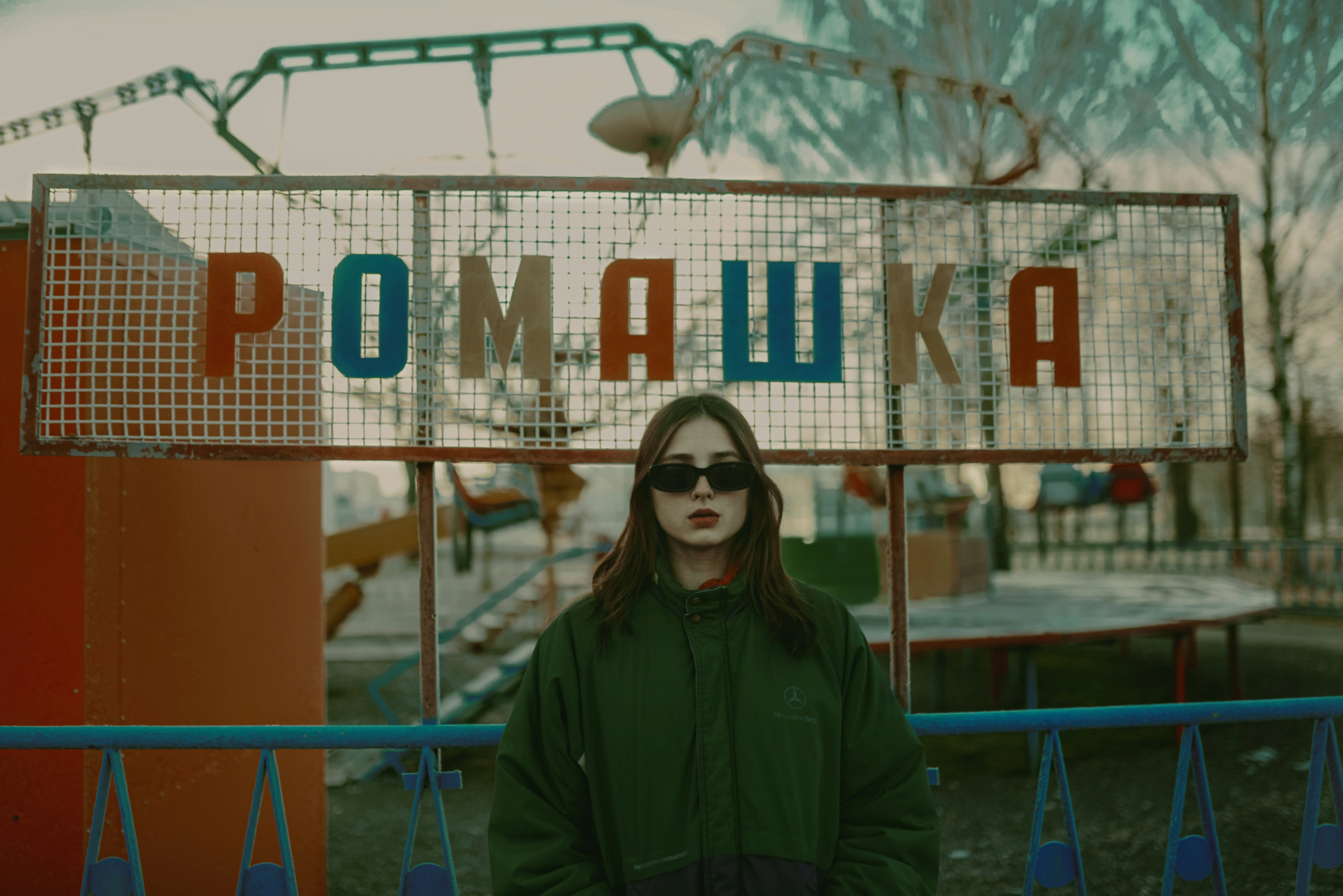 a woman wearing sunglasses standing in front of a sign