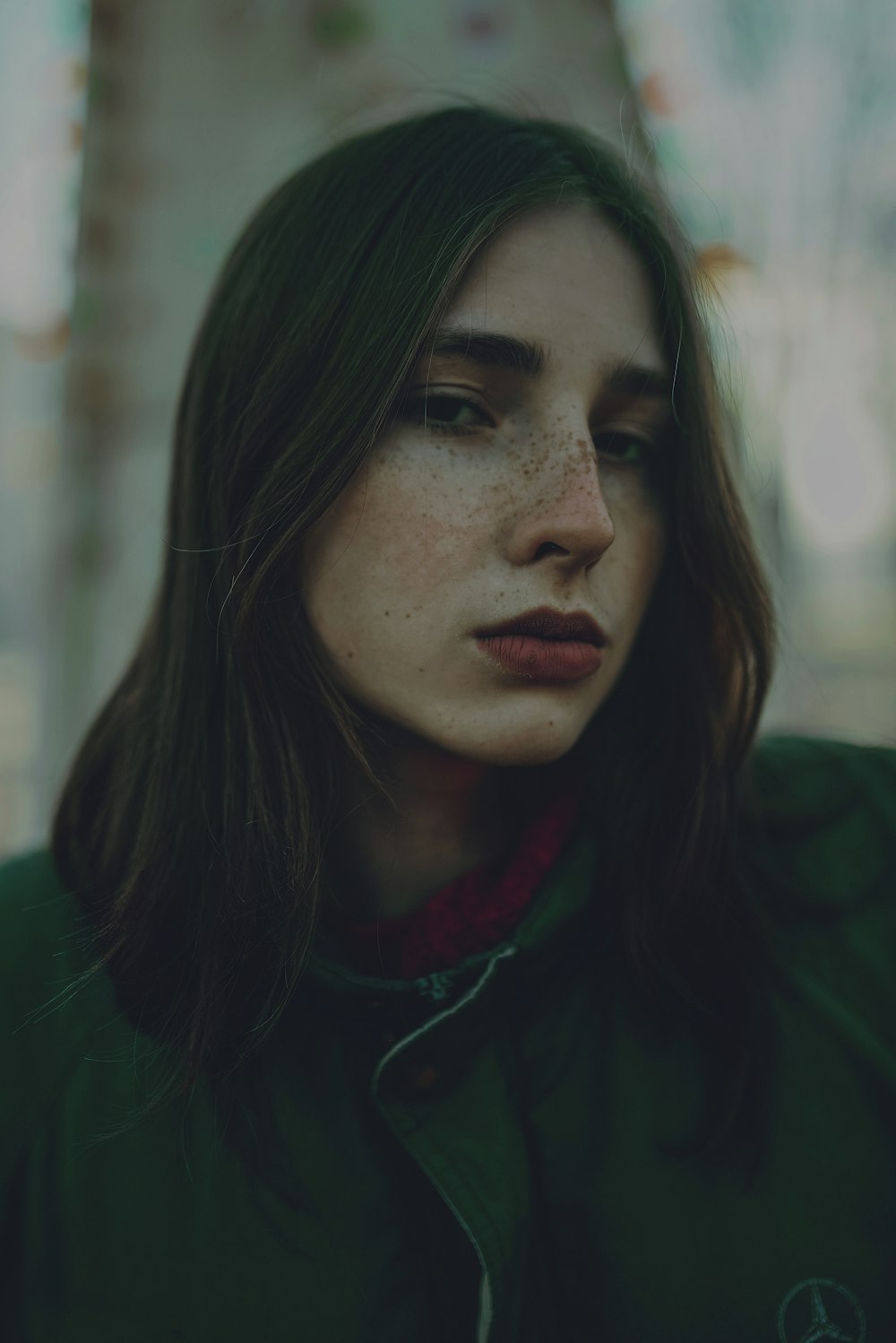 a woman with freckled hair and a green jacket