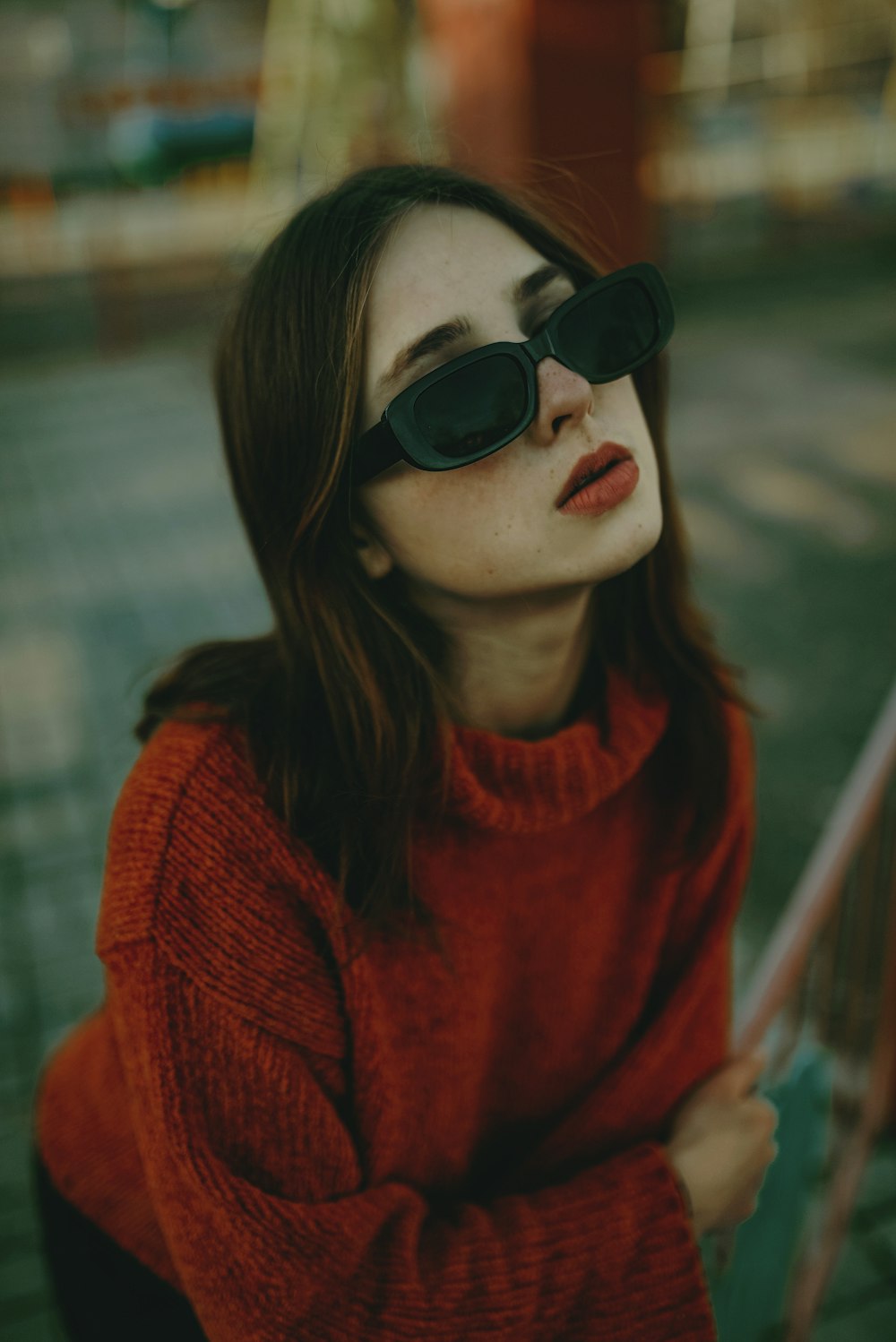 a woman in a red sweater and black sunglasses