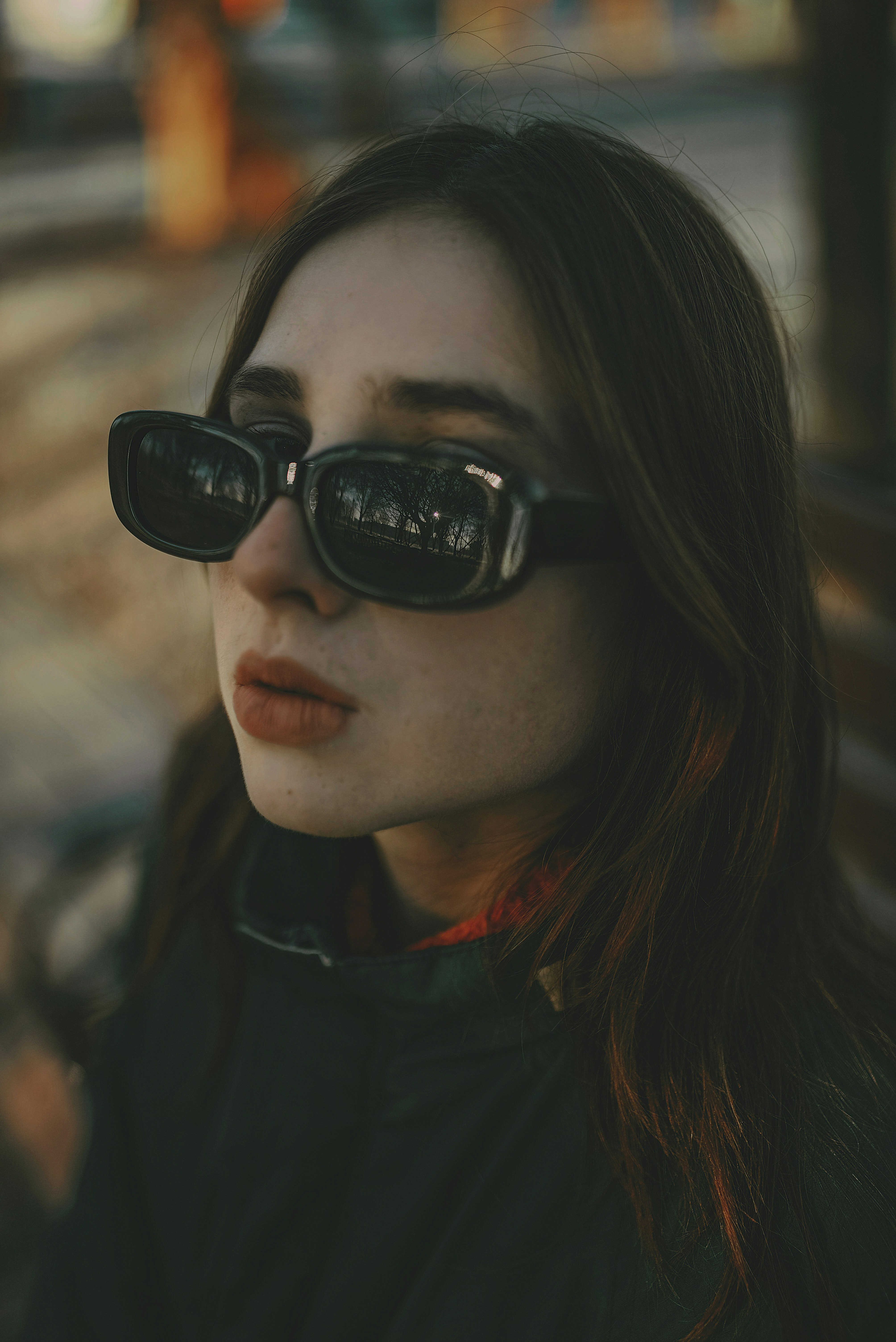 a woman wearing sunglasses and a black jacket