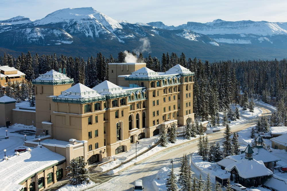 a large building surrounded by snow covered mountains