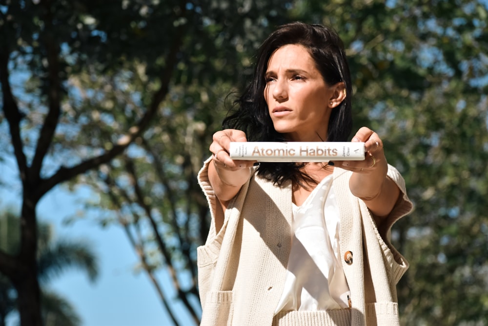 a woman holding up a tube with a label on it