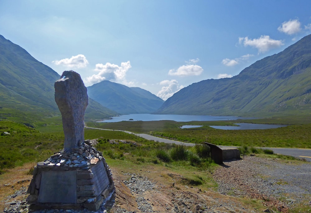 a statue of a person standing on top of a hill