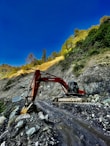 an excavator digging through a rocky area