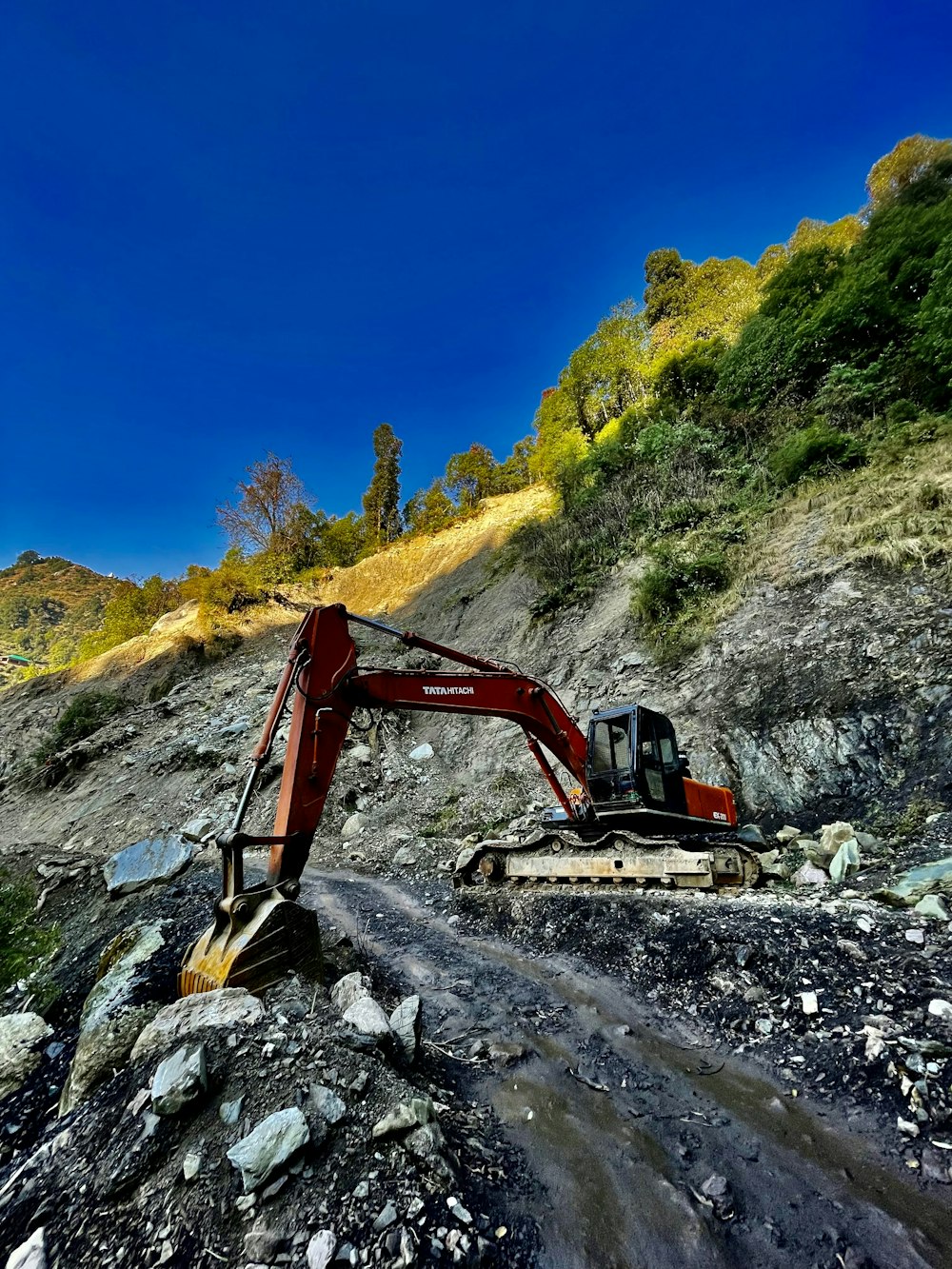 an excavator digging through a rocky area