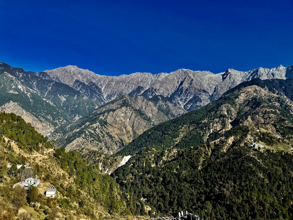 Una vista panorámica de una cadena montañosa con casas en primer plano