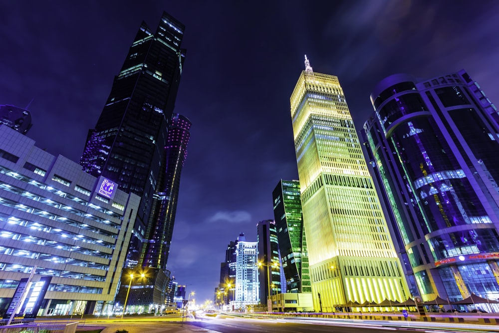 a city street at night with tall buildings