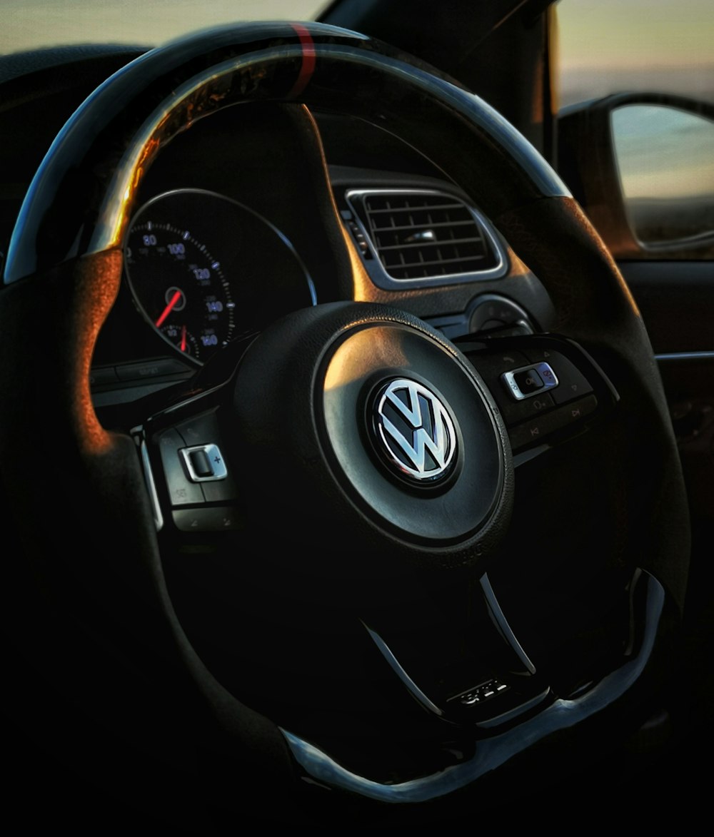 the steering wheel of a volkswagen car at sunset