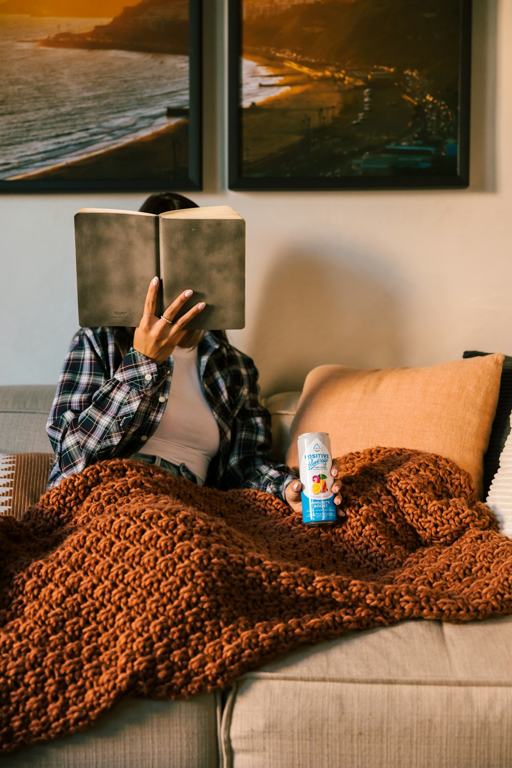 a person laying on a couch reading a book