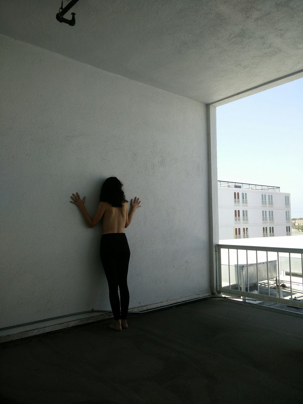 a woman leaning against a wall with her hands in the air