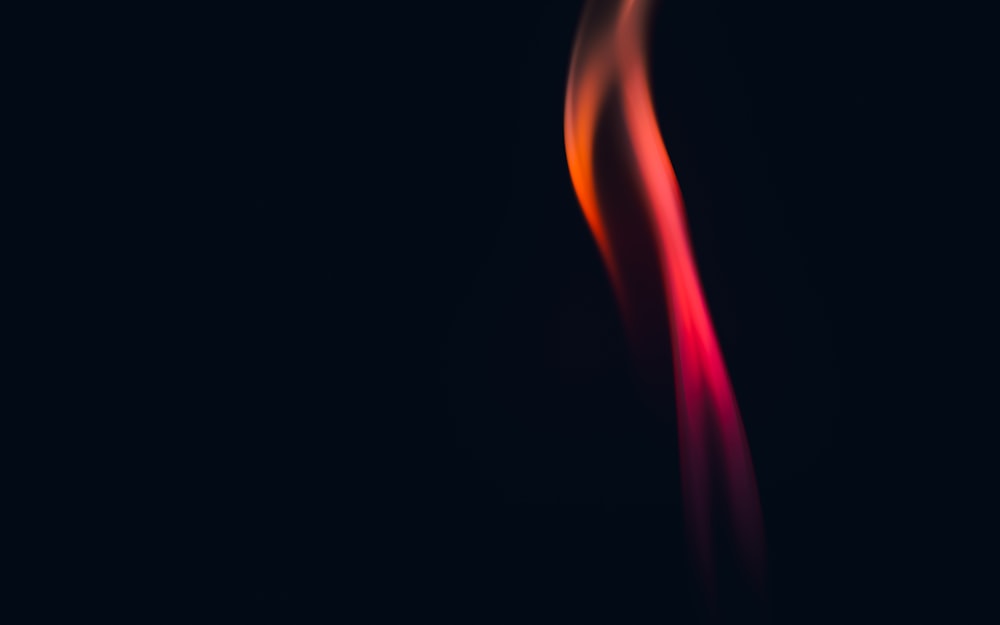 a close up of a red fire on a black background