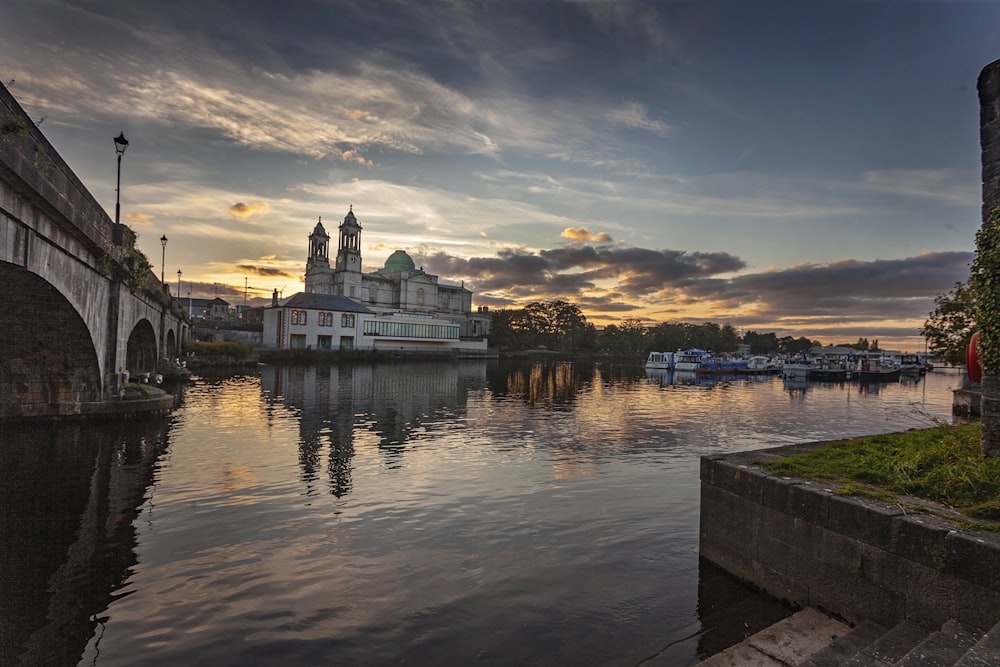 a body of water with a bridge and buildings in the background