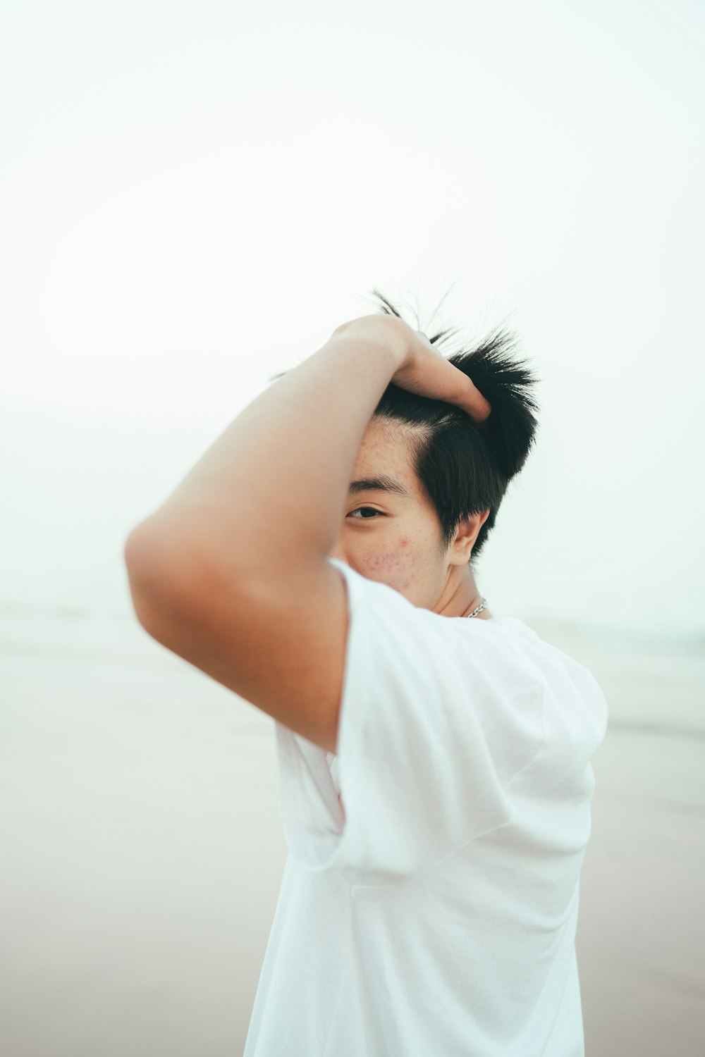 a man standing on top of a beach next to the ocean