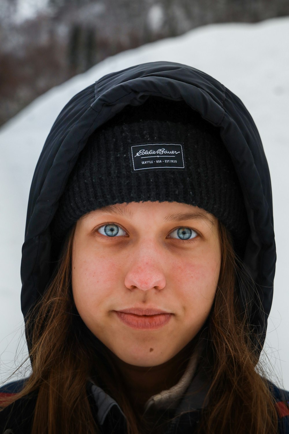 a woman with blue eyes wearing a black hat