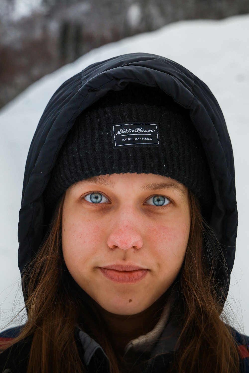 Une femme aux yeux bleus portant un chapeau noir