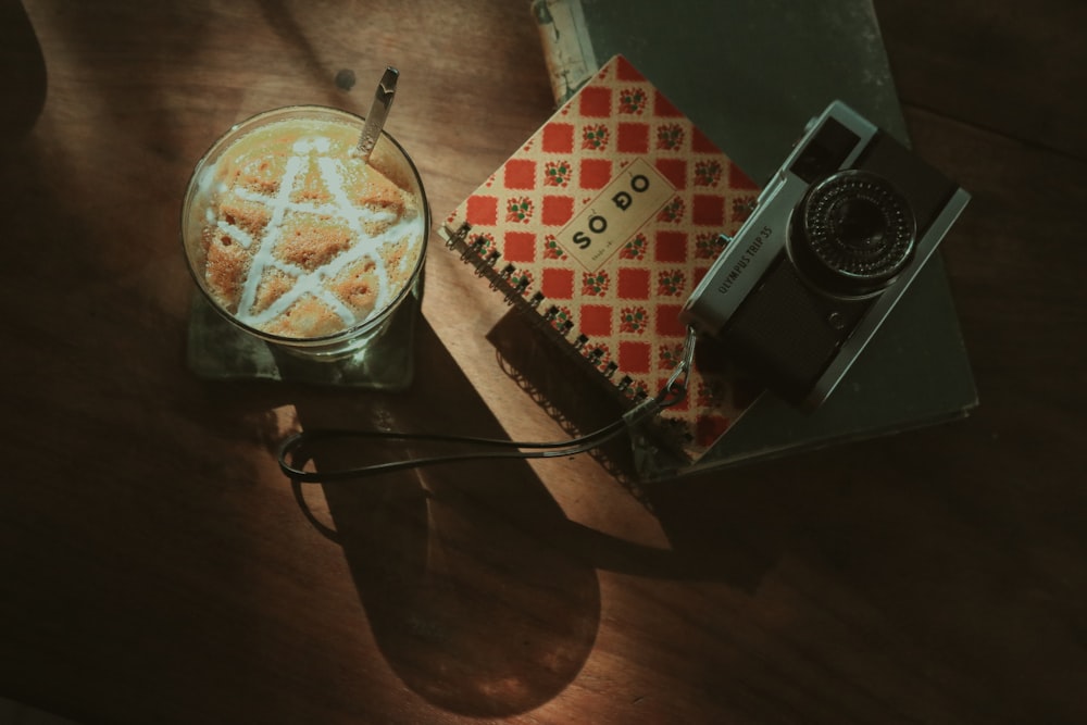 a cup of coffee and a camera on a table