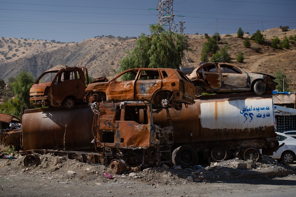 a rusted out truck sitting on top of a pile of junk