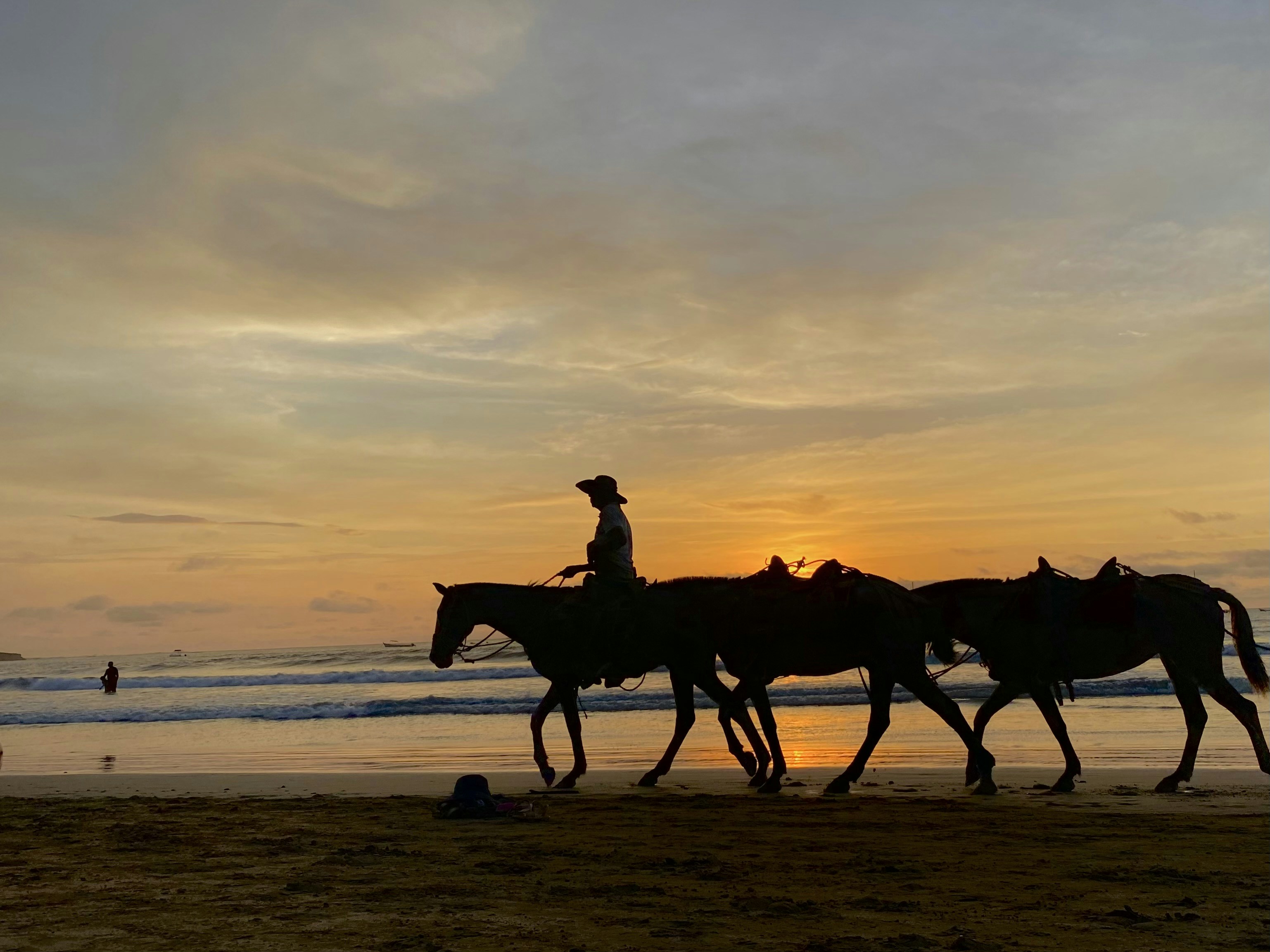a group of people riding horses on top of a beach, 