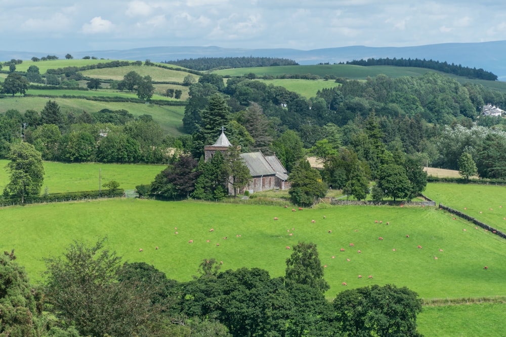 an aerial view of a farm house surrounded by lush green fields