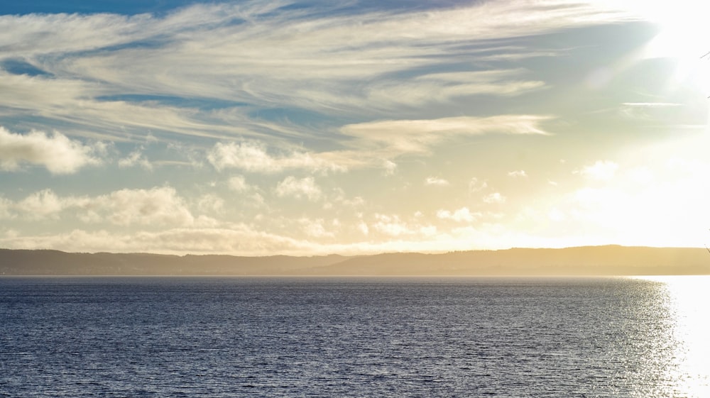 a large body of water under a cloudy sky