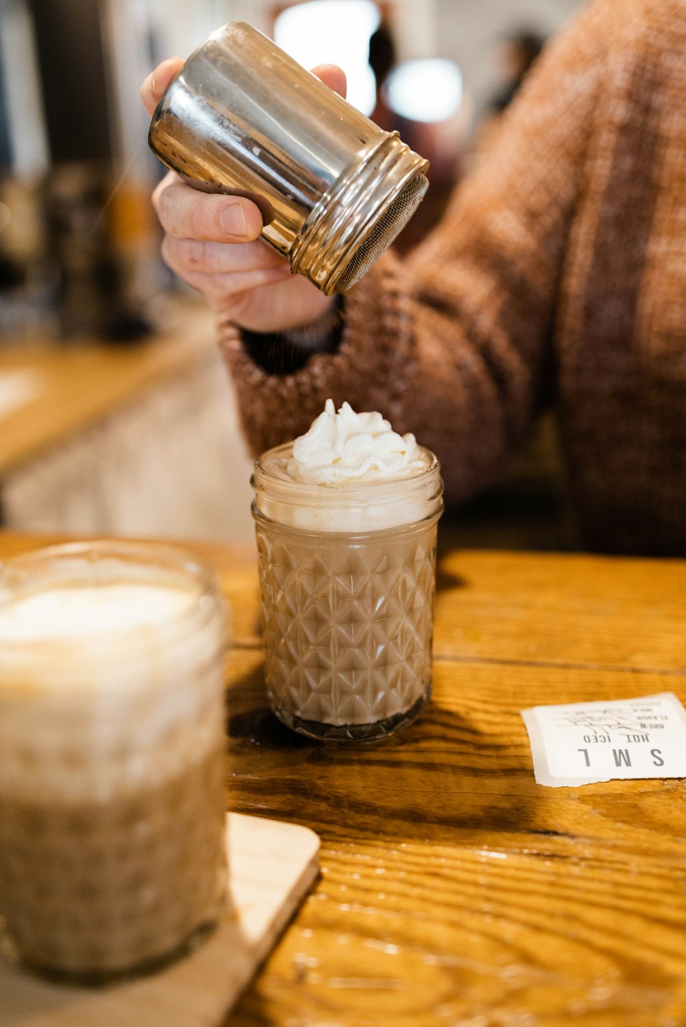 a person pouring a drink into a glass