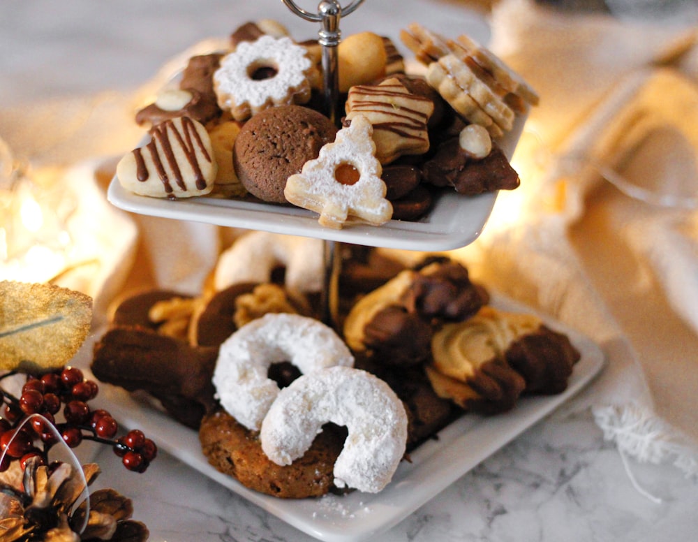 a three tiered tray of cookies and pastries