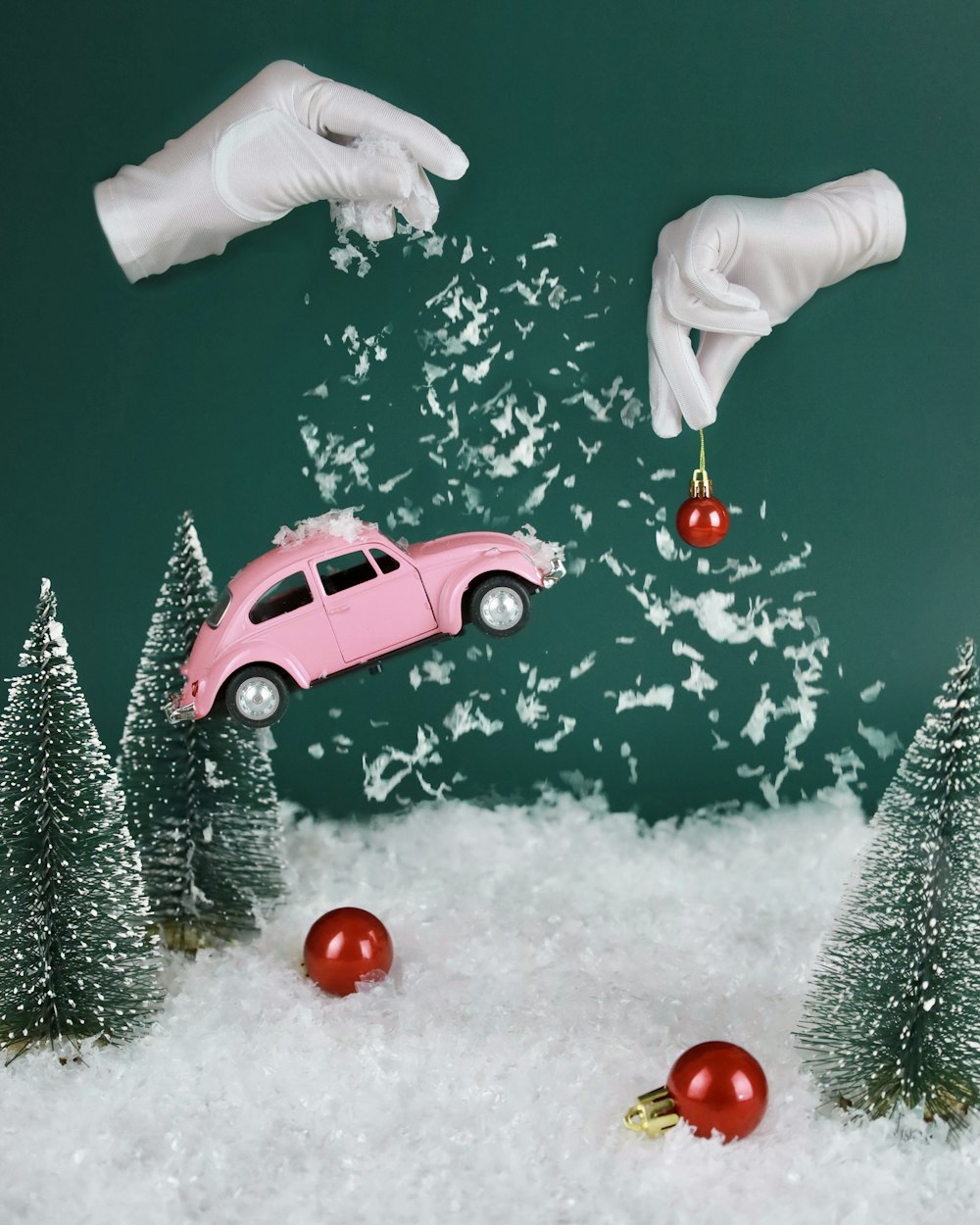 a pink car is in the snow with christmas decorations