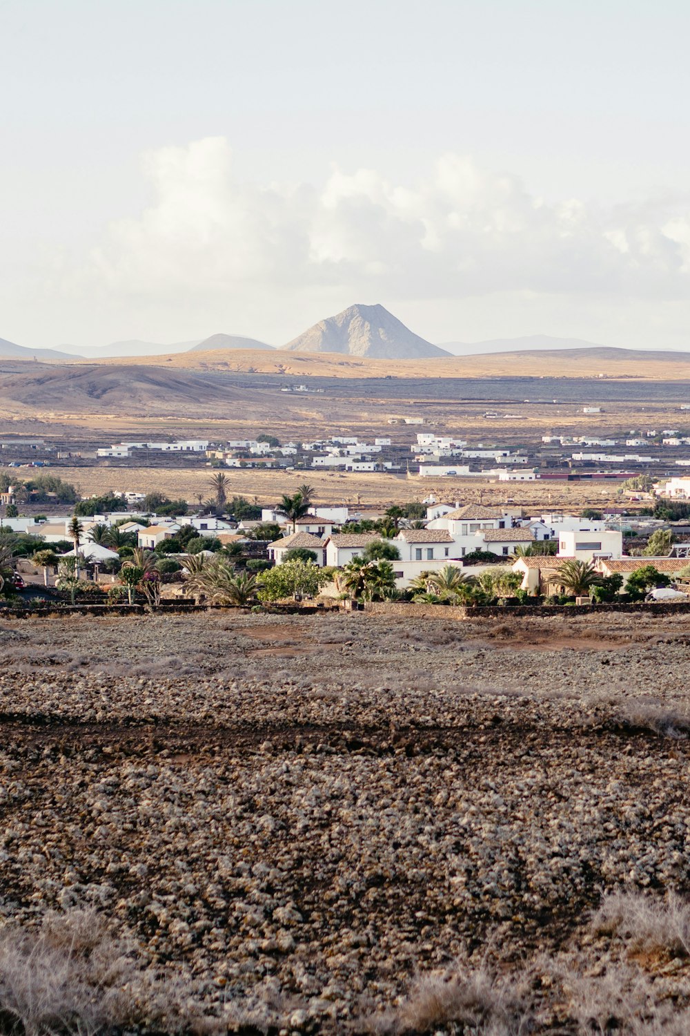 a view of a town in the distance with mountains in the background