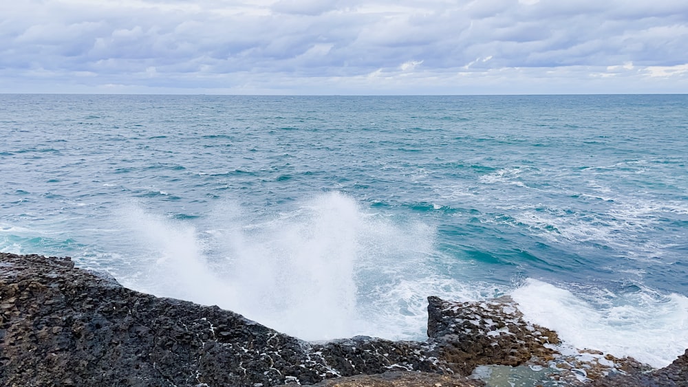 a large body of water sitting next to a rocky shore