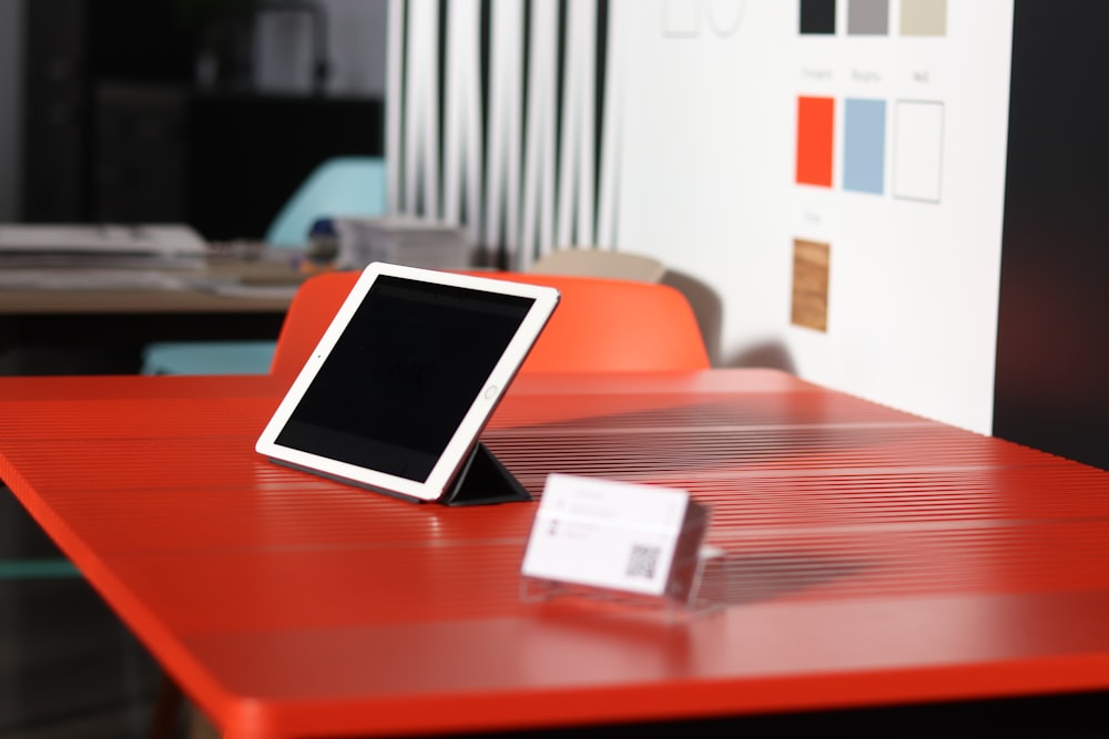 a tablet sitting on top of a red table