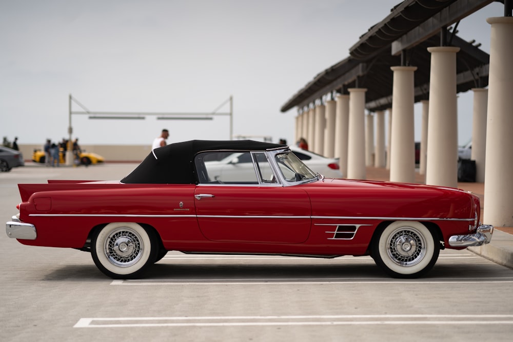 a red convertible car parked in a parking lot